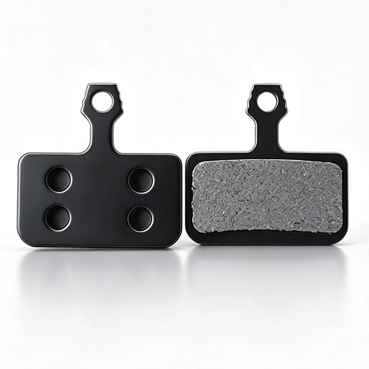  ZorixBike Ride Card Two black rectangular brake pads shown side by side on a clean white background, with one pad facing forward to show the textured gray friction surface and the other showing the back with four circular cutouts.