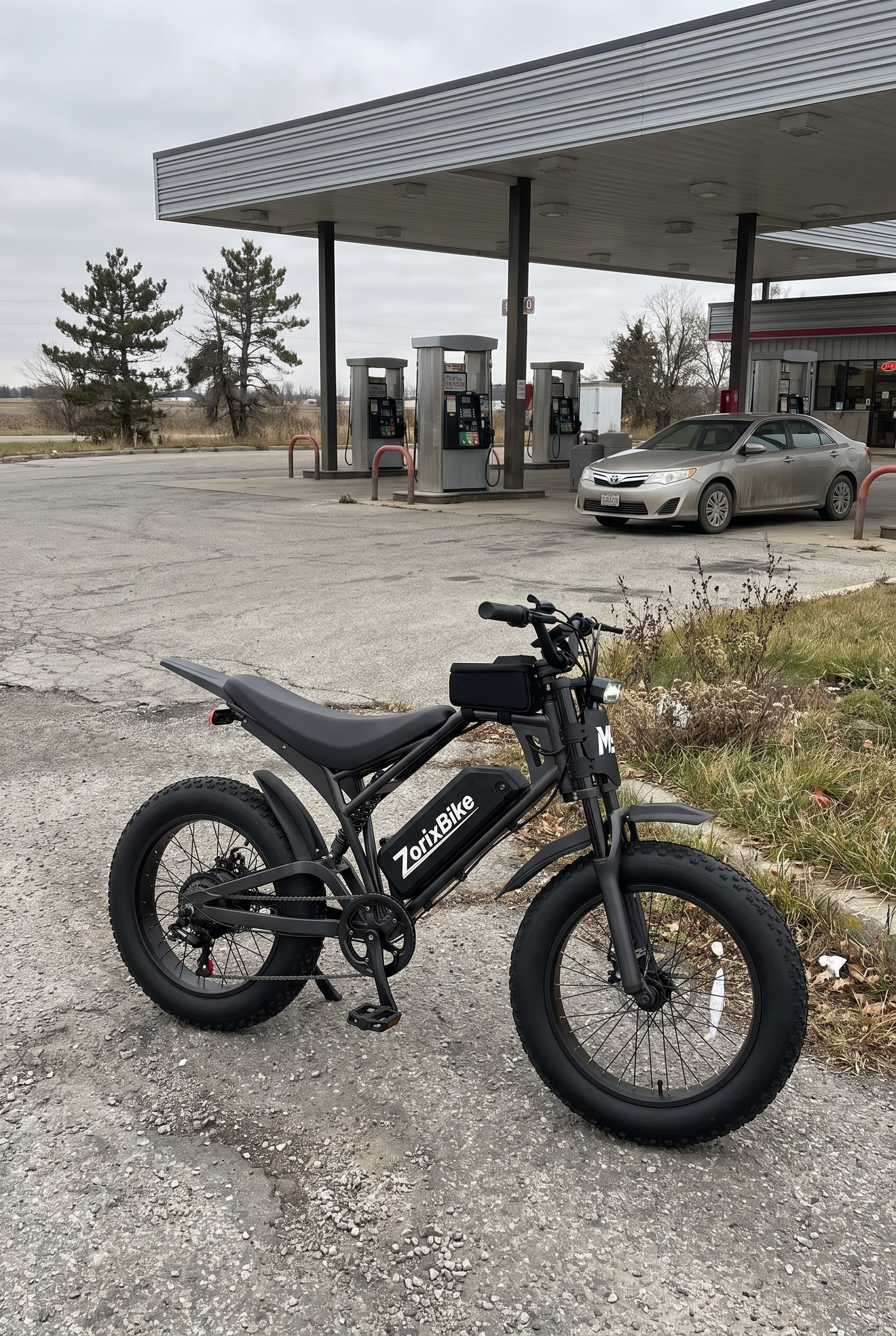 Real photos of ZorixBike M9 Electric bike parked in front of a gas station with a car in the background.